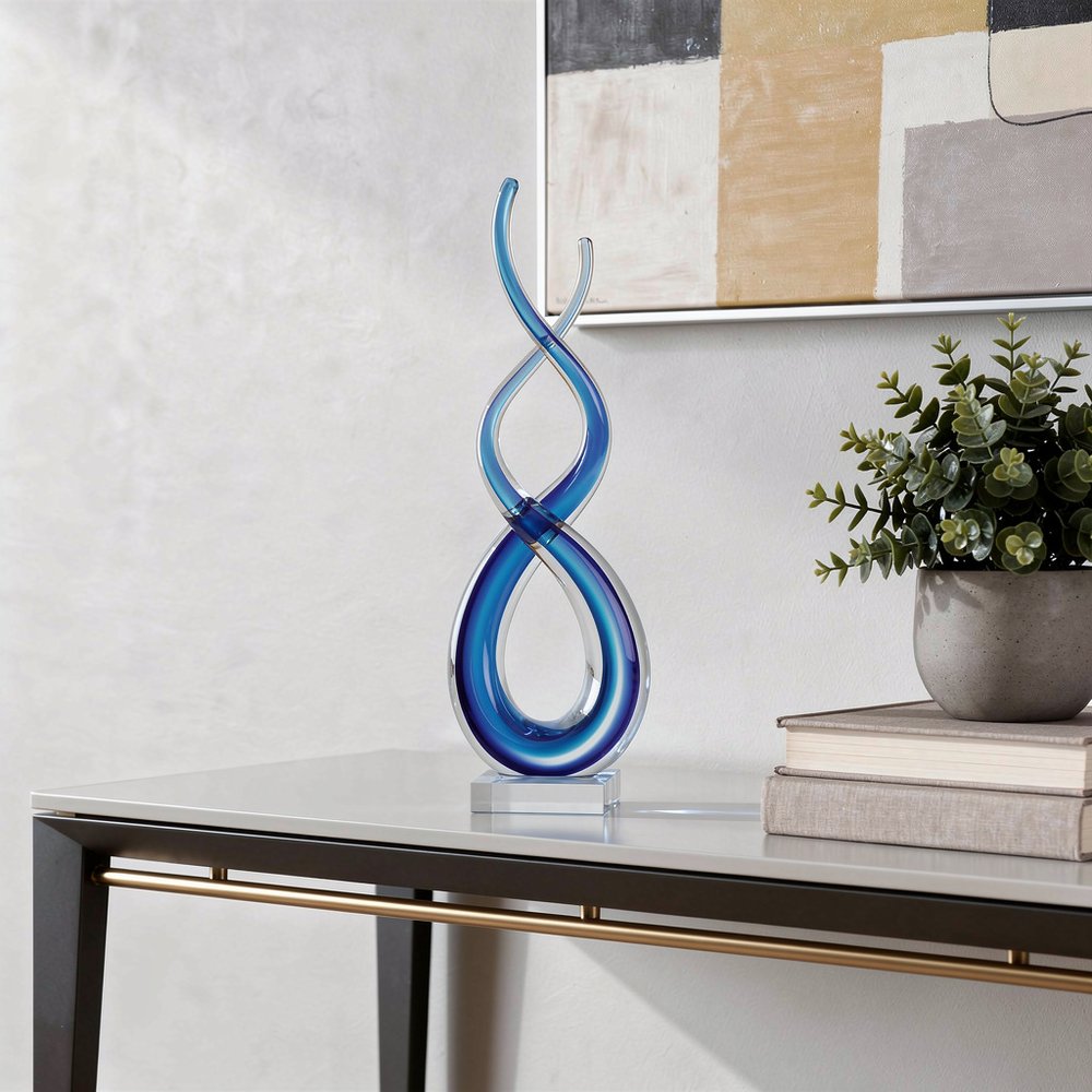 20" Clear and Blue Murano Glass Modern Abstract Tabletop Sculpture styled in a furnished interior with an off-white wall on a off-white floor.