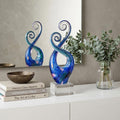 12" Blue and Green Murano Glass Modern Abstract Tabletop Sculpture styled in a furnished interior with a tan wall on a off-white floor.