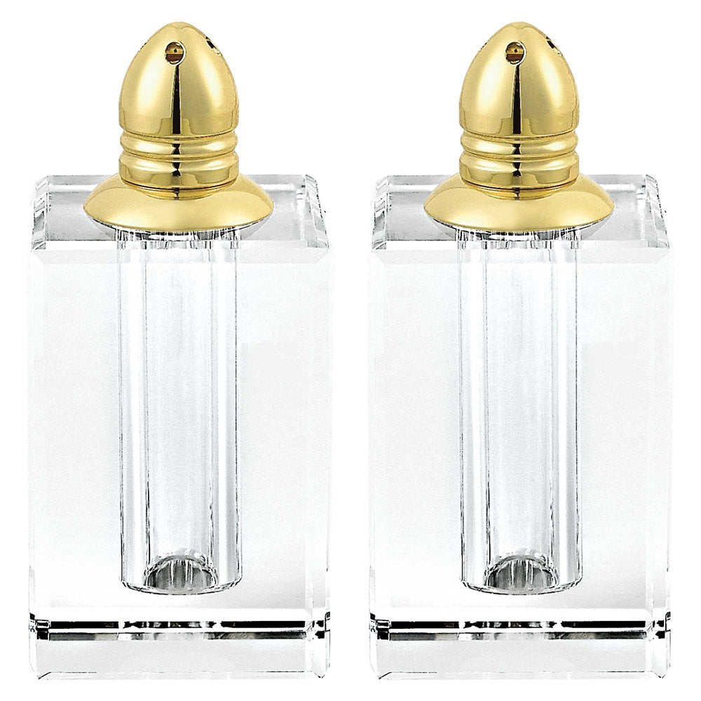 Two clear crystal pepper shakers with gold tops on a white background.