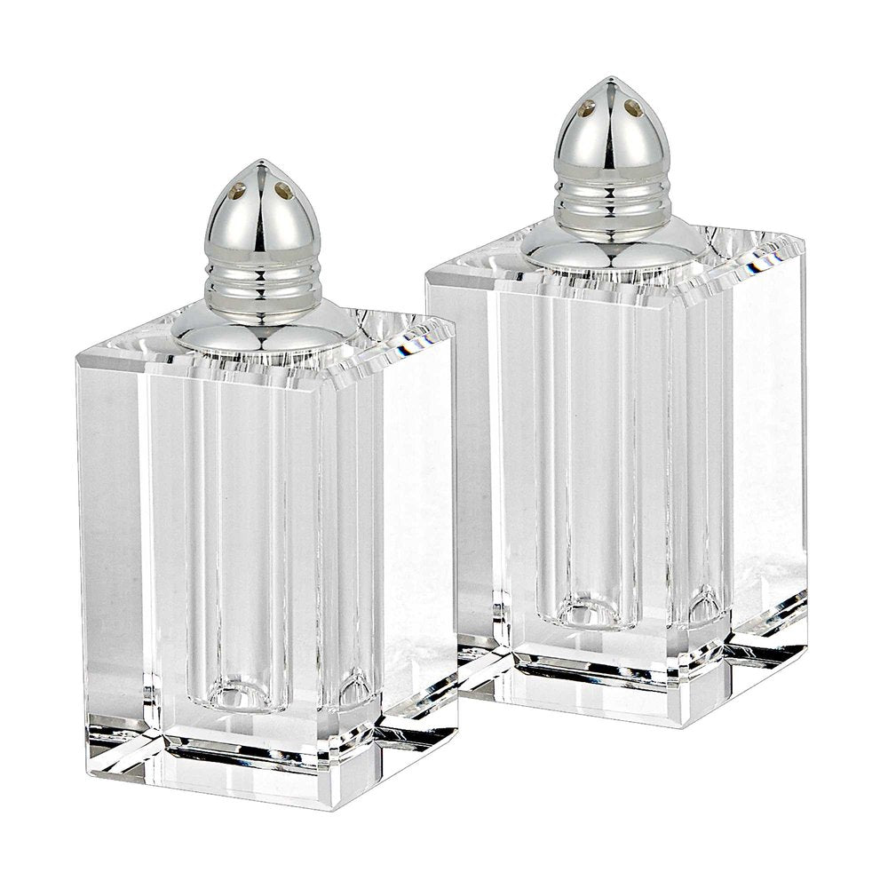 Two clear crystal pepper shakers with silver tops on a white background.
