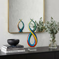 16" Clear Red Blue Yellow Murano Glass Modern Abstract Tabletop Sculpture styled in a furnished interior with an off-white wall on a black floor.