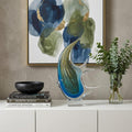 17" Blue Murano Glass Fish Figurine Tabletop Sculpture styled in a furnished interior with a tan wall on a off-white floor.
