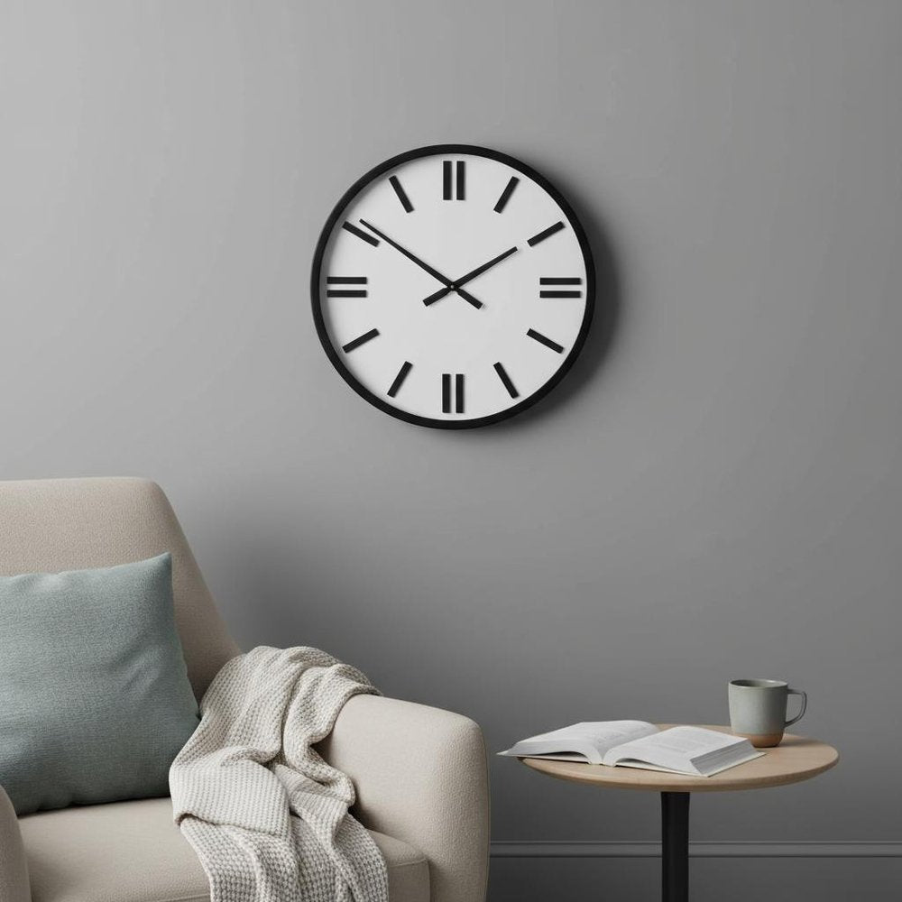 24" Round Large Modern Wall Clock With White Face And Non-Numarical Number styled in a furnished interior with a gray wall on a charcoal floor in black.