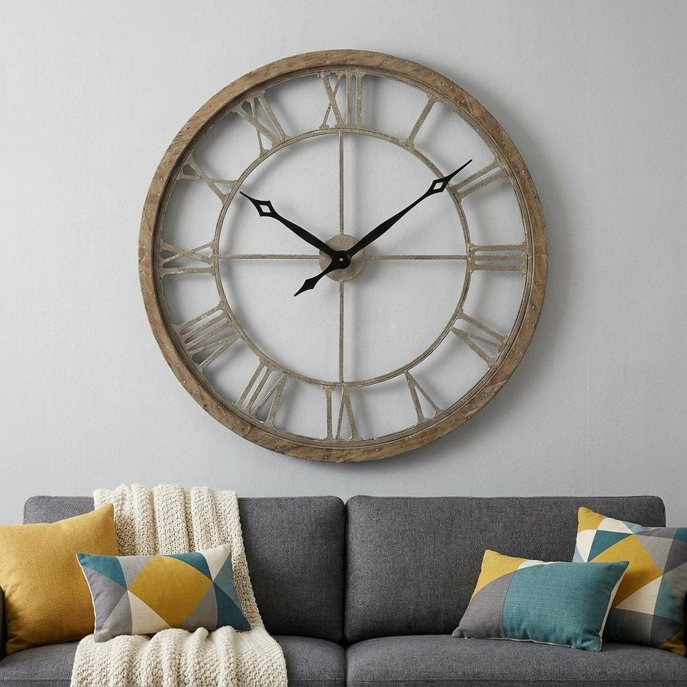 32" Circle Brown Metal Skeleton Wall Clock styled in a furnished interior with a light gray wall on a charcoal floor.