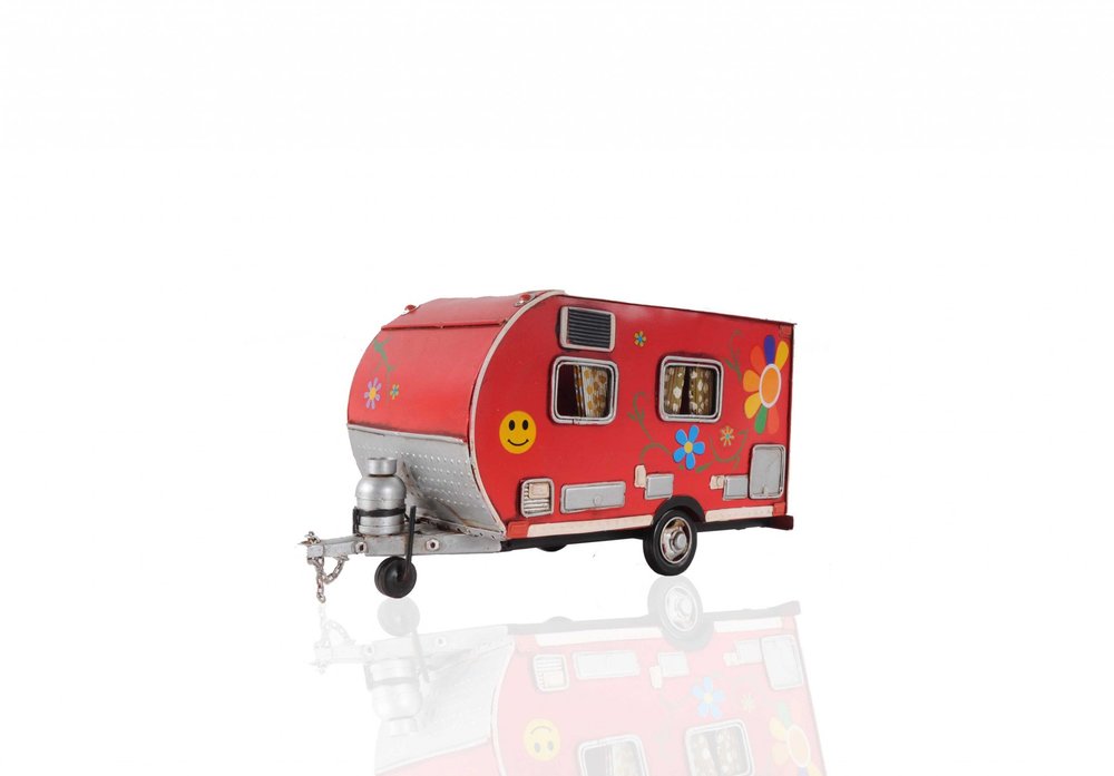 Red metal camper trailer model tissue holder with floral and smiley face decorations on a white background.