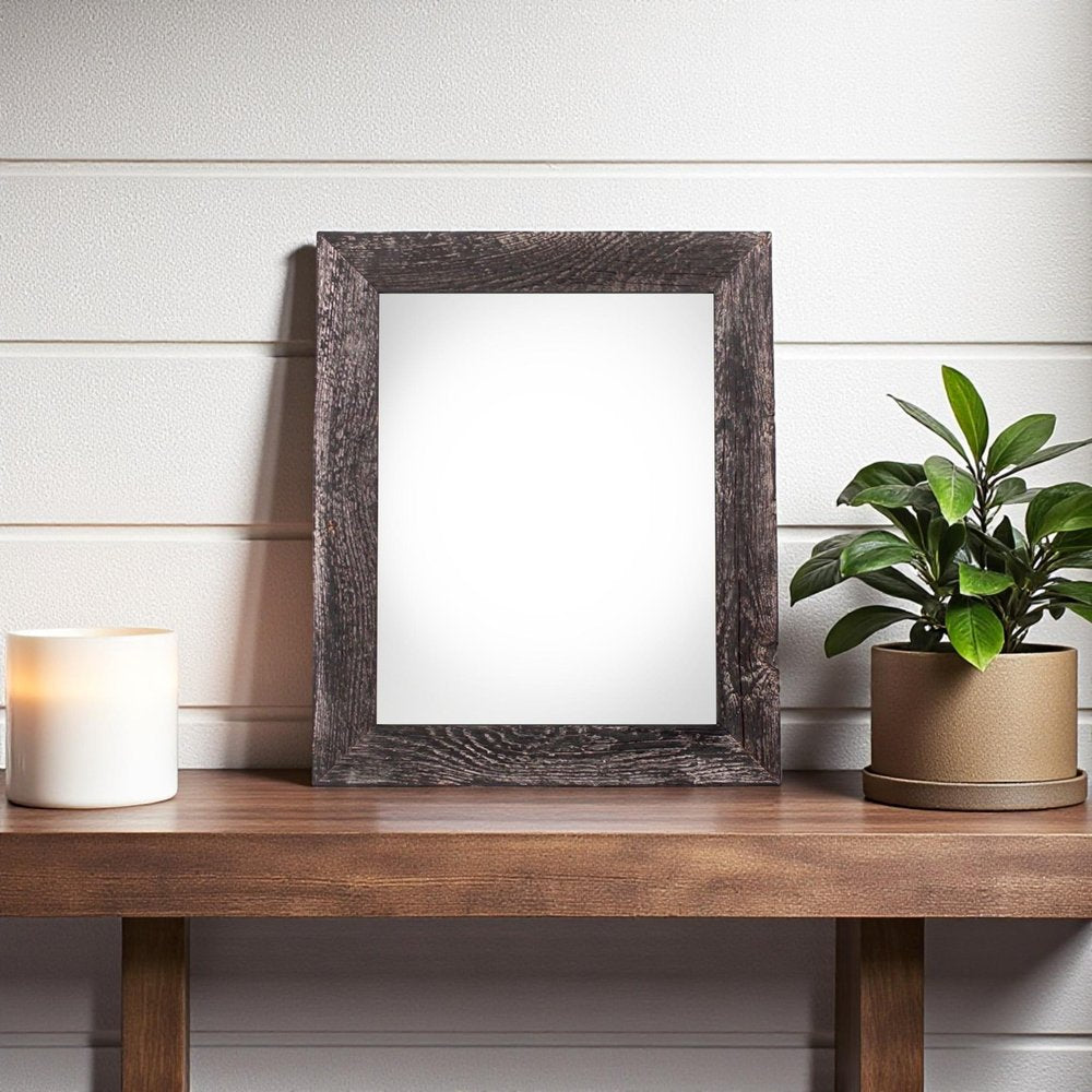5" x 7" Black Solid Wood Tabletop Picture Frame styled in a furnished interior with an off-white wall on a charcoal floor.