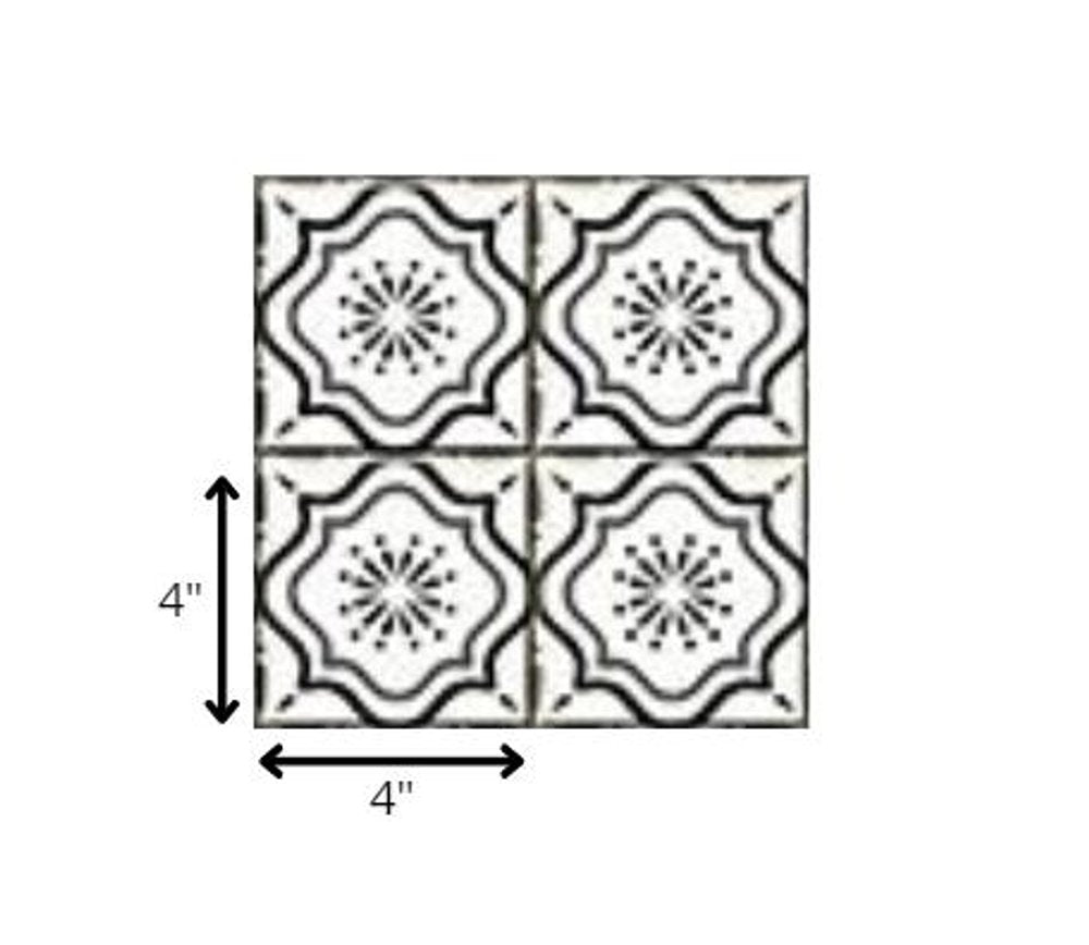 Four 4" x 4" black and white mosaic peel and stick tiles with a floral pattern on a white background.