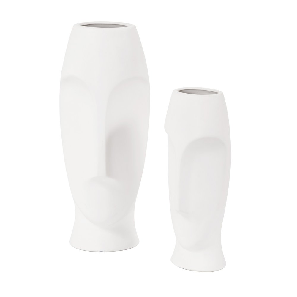 Two white ceramic vases shaped like abstract faces on a white background.