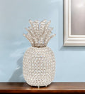 15" Silver Faux Crystal Decorative Pineapple shown outdoors on an outdoor setting.