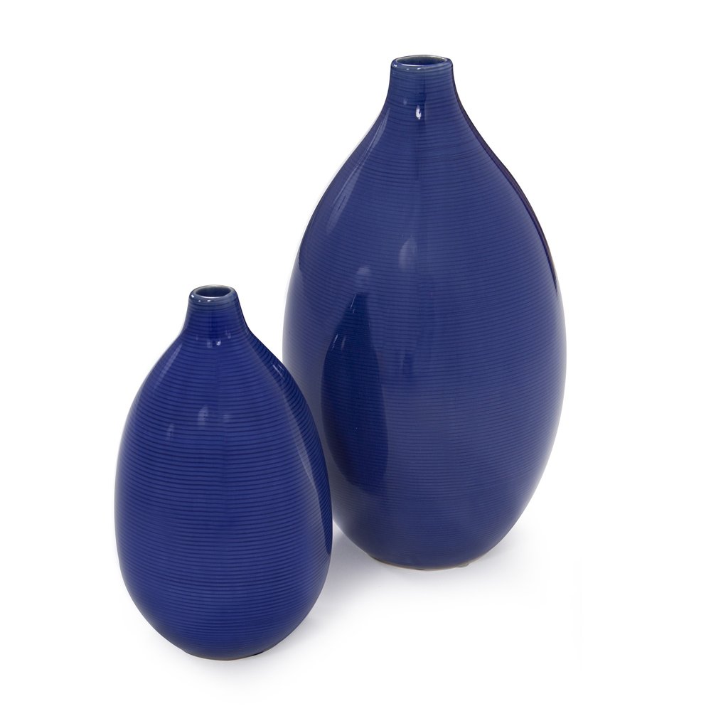 Two cobalt blue ceramic vases with ribbed texture on a white background.