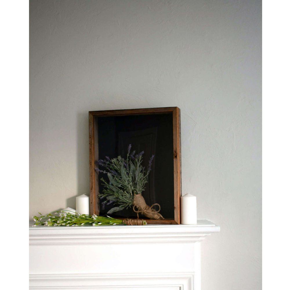 Gray solid wood tabletop picture frame with a bouquet of lavender and white flowers on a white mantelpiece.