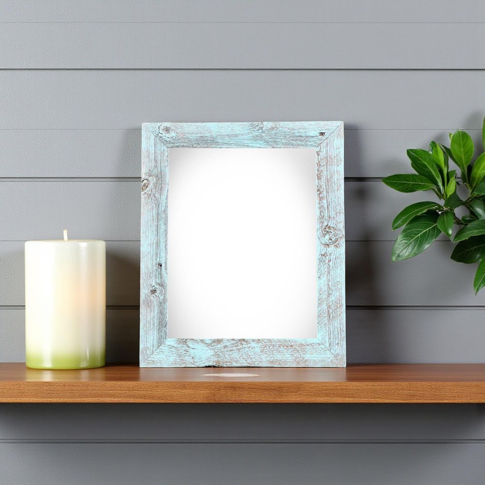 4" x 6" Blue Solid Wood Tabletop Picture Frame styled in a furnished interior with a light gray wall on a charcoal floor.