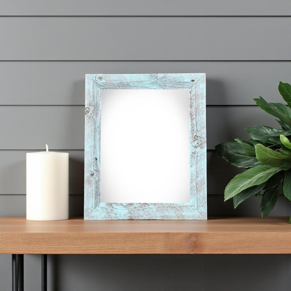 5" x 7" Blue Wood Tabletop Picture Frame styled in a furnished interior with a gray wall on a charcoal floor.