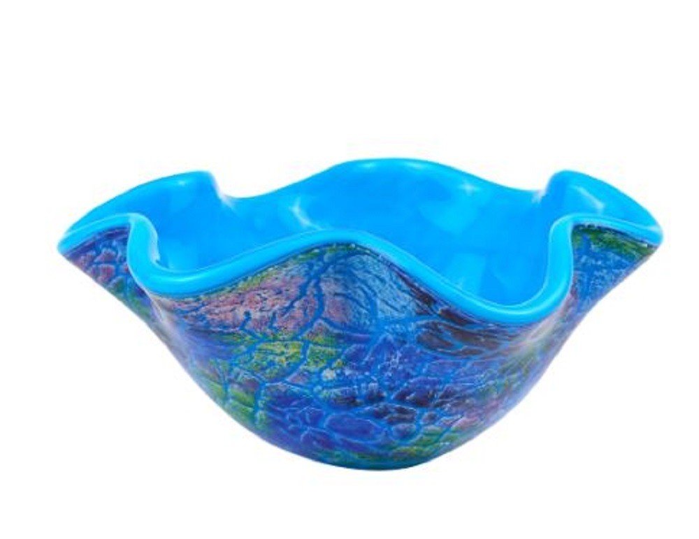 A blue glass centerpiece bowl with a ruffled edge and a textured blue, green, and purple pattern on the exterior, set against a white background.