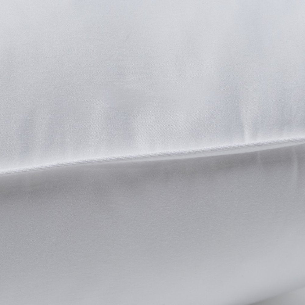 Close-up of a white queen size pillow with a visible stitched seam, showing the fabric texture.
