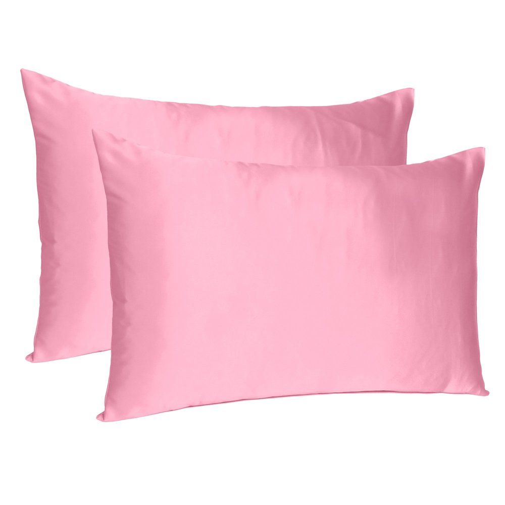 Two pink silky satin standard pillowcases on a white background.