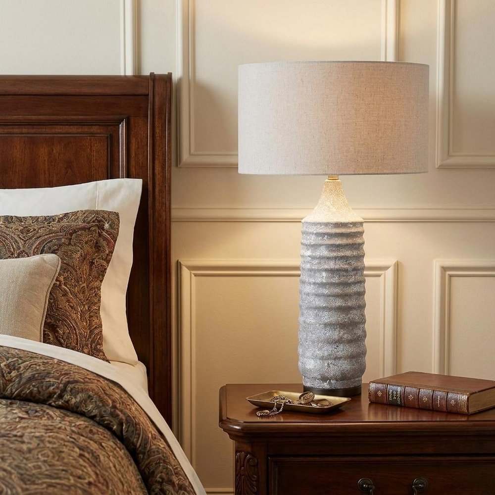 31" Gray Lamp Base LED With Beige Shade styled in a furnished interior with a cream wall on a black floor.