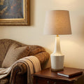 29" Brown Lamp Base LED With Brown Shade styled in a furnished interior with a cream wall on a dark wood floor.
