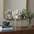 10" White Metal Tabletop Sculpture styled in a furnished interior with a light gray wall on a dark wood floor.