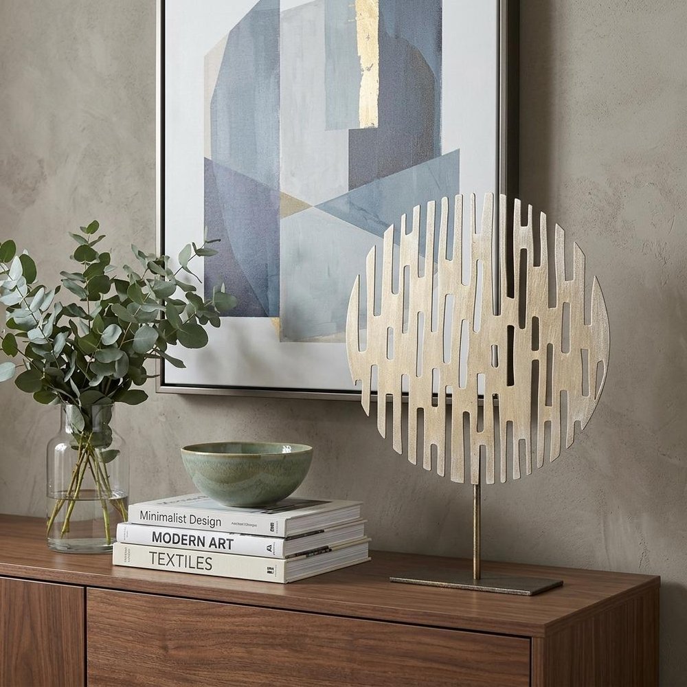 17" Antiqued Gold Round Disc Metal Tabletop Sculpture shown outdoors on an outdoor setting.