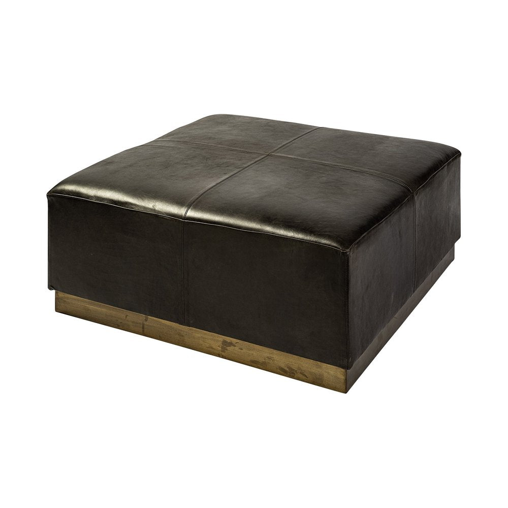 Square black faux leather ottoman with a brass-finished base on a white background.