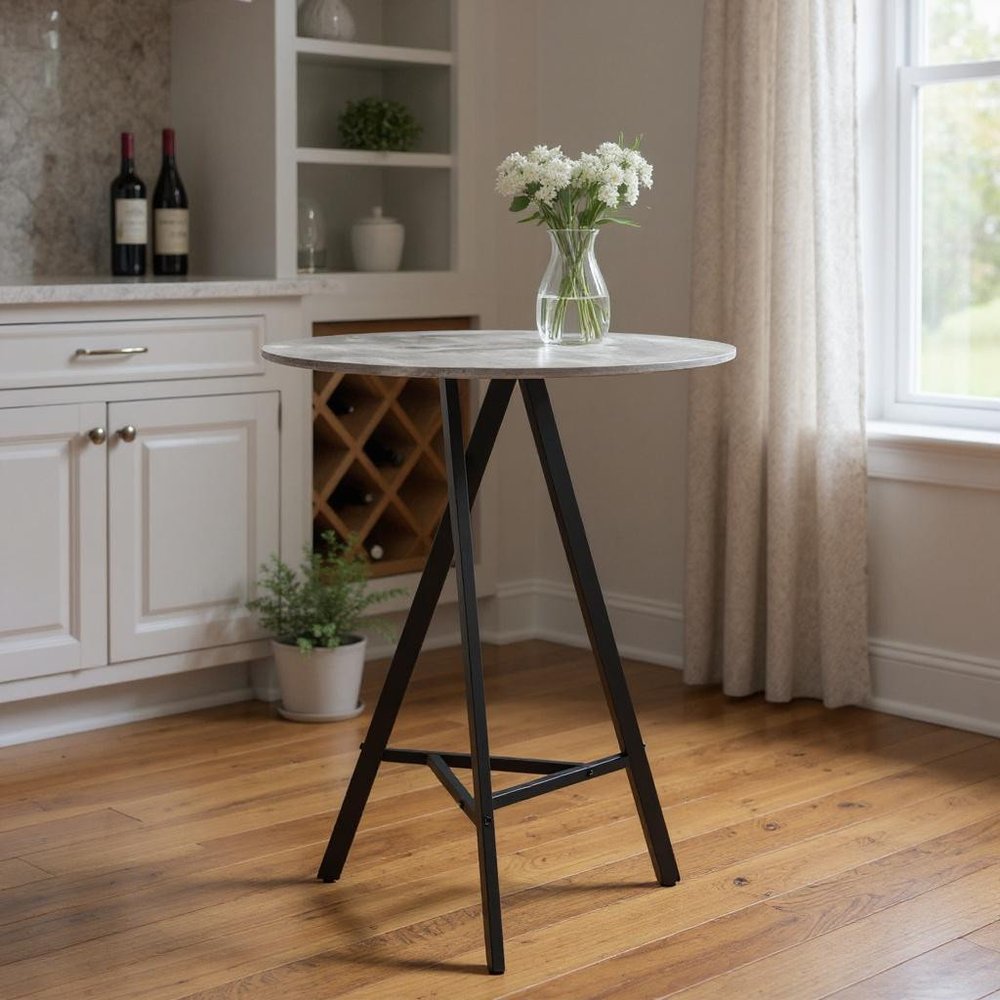 32" Gray and Black Rounded Steel Bar Table styled in a furnished interior with a brown wall on a wood floor.