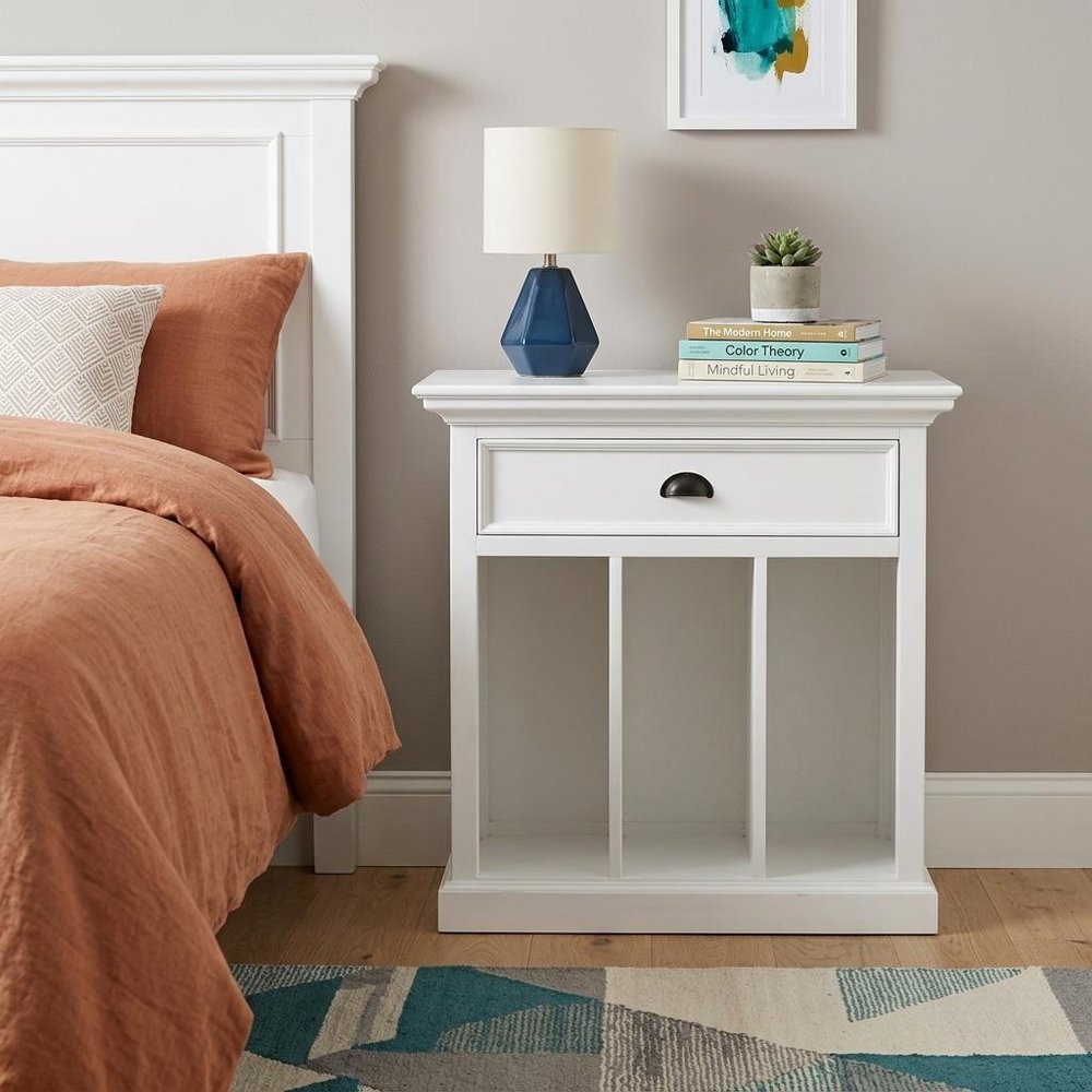 31" White Solid and Manufactured Wood Nightstand styled in a furnished interior with a light gray wall on a dark wood floor.