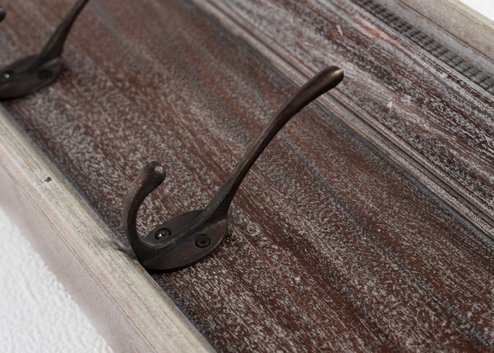 28" Brown Solid Wood Four Hook Wall Mount Coat Rack styled in a furnished interior with a gray wall on a dark wood floor.
