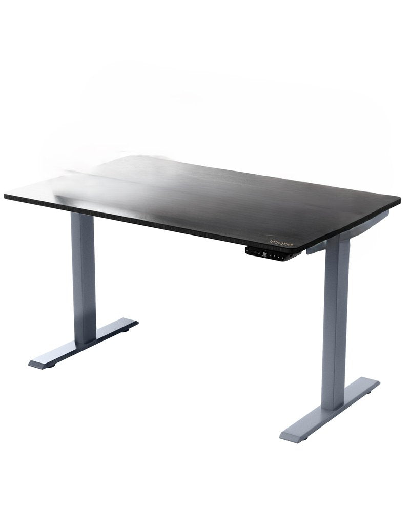 Adjustable standing desk with a black wood grain top and gray metal legs on a white background.