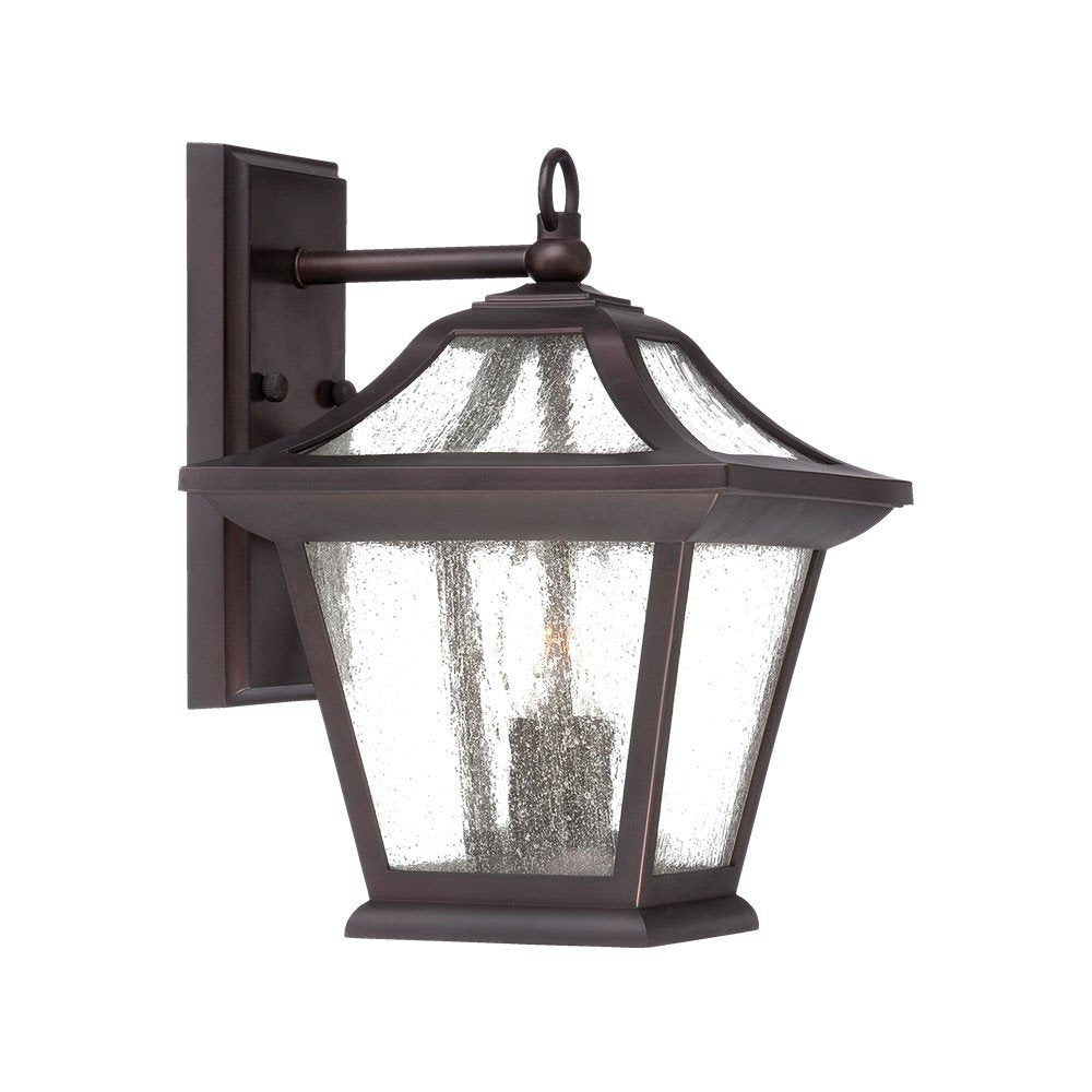 Antique bronze outdoor wall light with seeded glass panels and a birdhouse shape, mounted on a white background.