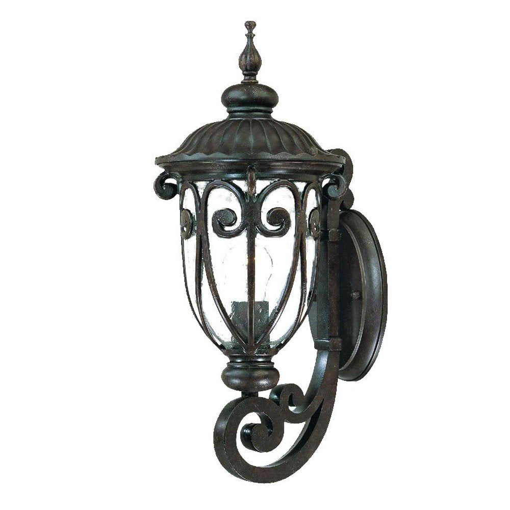 Traditional dark brown metal wall sconce with clear glass and ornate scrollwork, isolated on a white background.