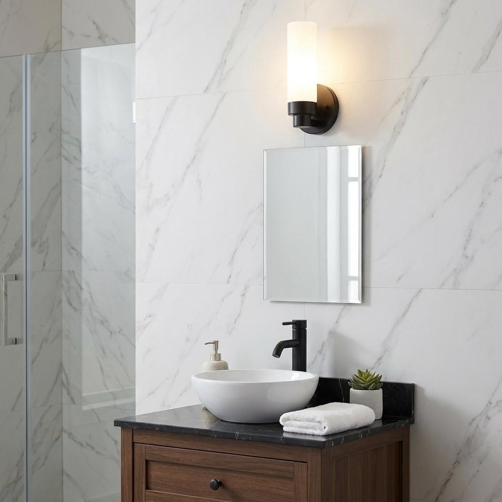 Matte Black Wall Light with Narrow Frosted Glass Shade in a home interior