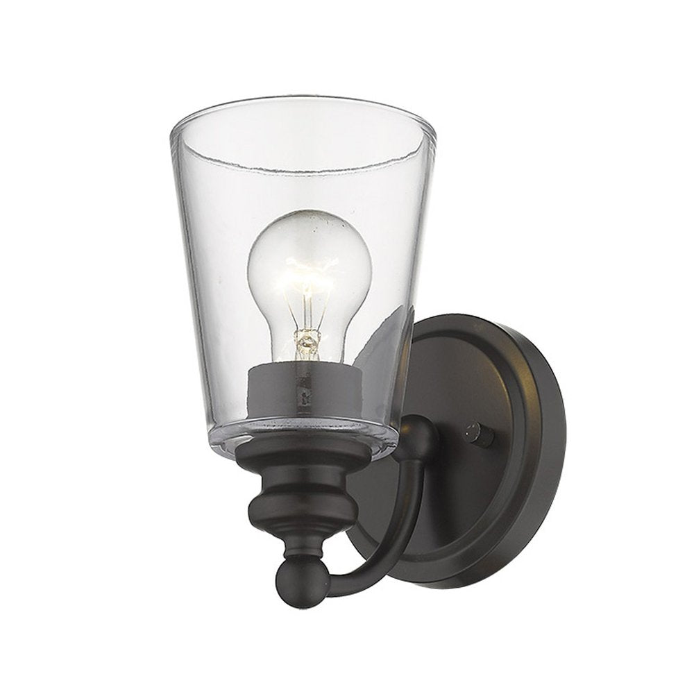 Antique bronze wall sconce with a clear glass shade and exposed light bulb on a white background.