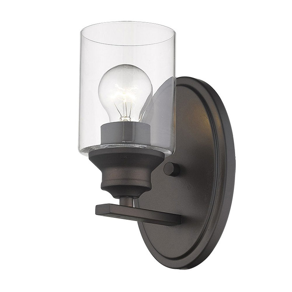 A bronze wall light with a clear glass shade and a visible light bulb against a white background.