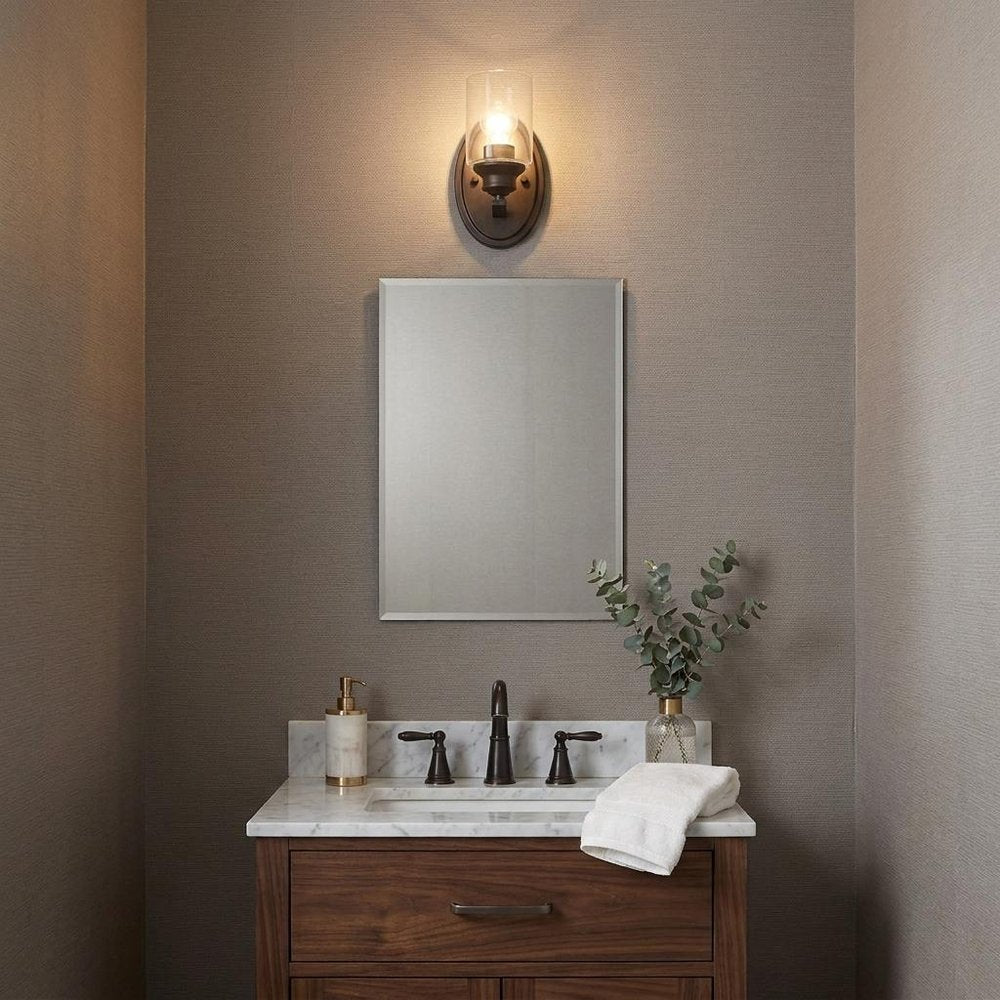 One Light Bronze Wall Light with Clear Glass Shade in a home interior