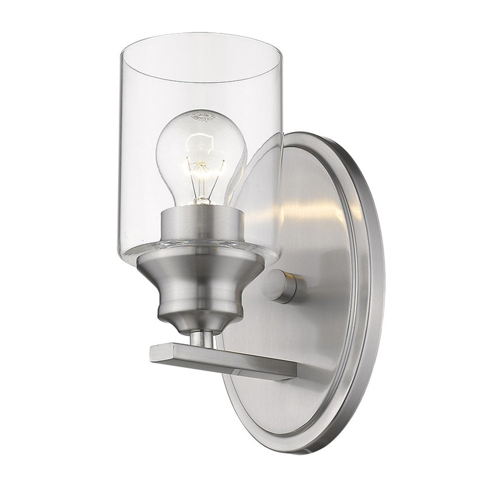 A silver wall light with a clear glass shade and exposed bulb, mounted on a white background.