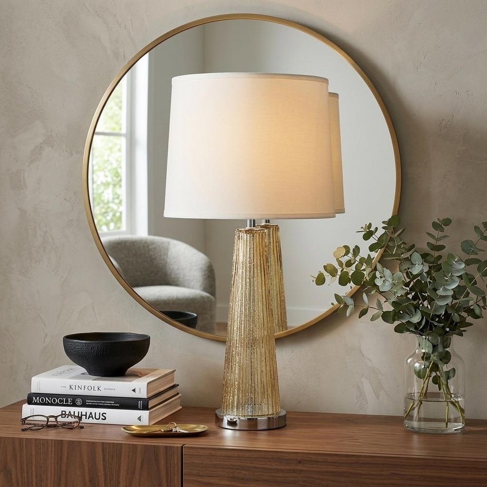 29" Champagne Glass Buffet Lamp With Off White Empire Shade styled in a furnished interior with a tan wall on a dark wood floor in off-white glass.
