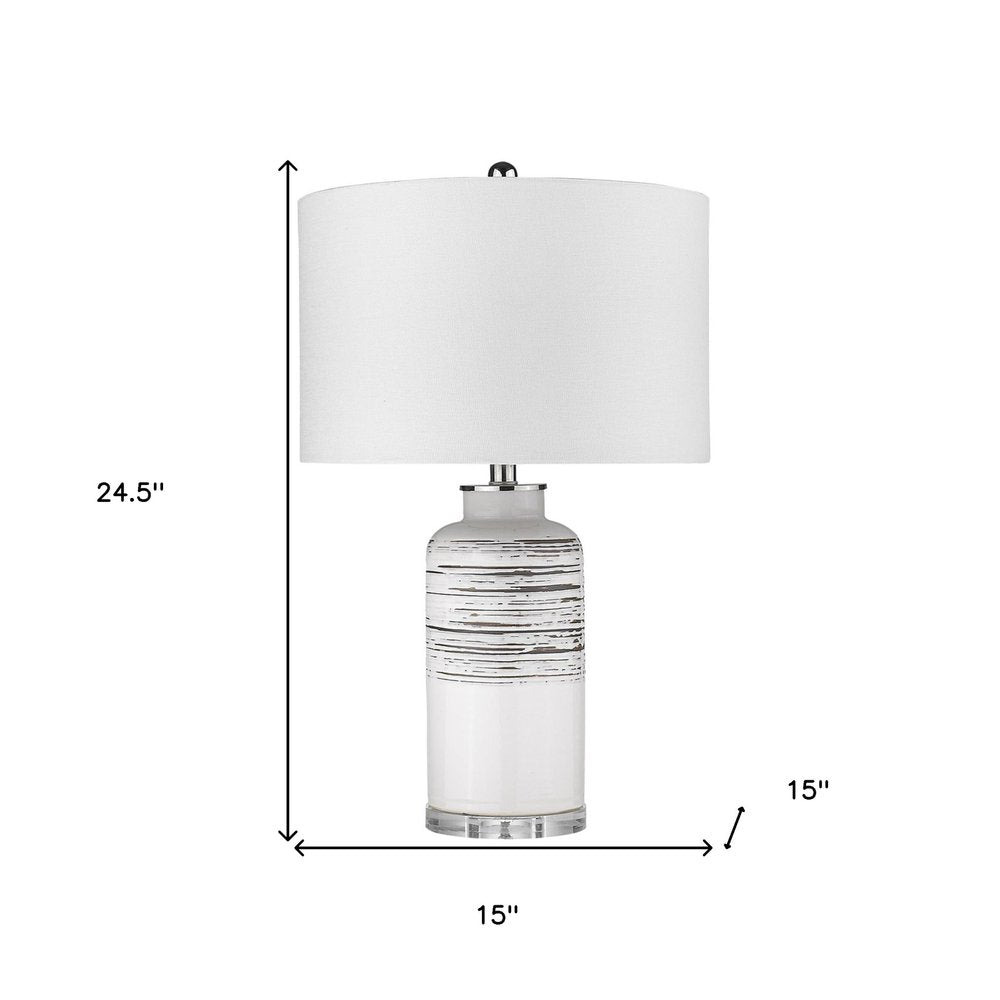 25" Black and White Ceramic Column Lamp With White Drum Shade. Lamp isolated on a plain white background, showing a white ceramic surface.