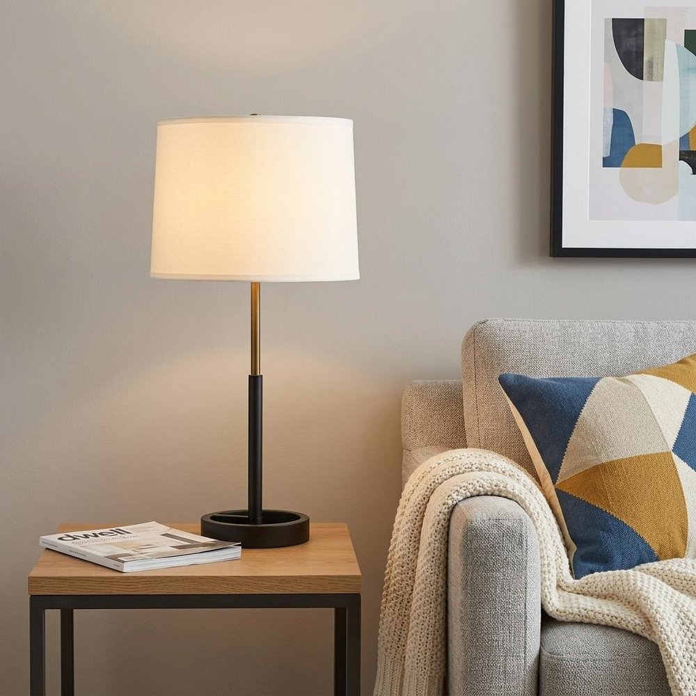 31" Black and Gold Metal Table Lamp With White Empire Shade displayed on a dark wood tabletop in a furnished interior against a tan wall.