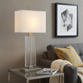 31" Silver Metal and Acrylic Buffet Lamp With White Shade styled in a furnished interior with a tan wall on a dark wood floor.