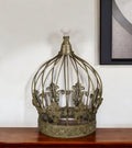 10" Bronze Metal Hand Painted Decorative Crown Tabletop Sculpture styled in a furnished interior with a light gray wall on a dark wood floor.