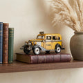 14" Yellow Checker Taxi Cab Model Sculpture styled in a furnished interior with a cream wall on a wood floor.