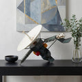 11" Dark Green Metal Hand Painted Model Airplane Tabletop Sculpture shown outdoors on an outdoor setting.