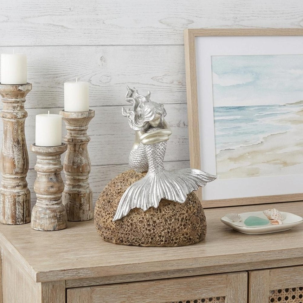 10" Brown and Silver Contemplative Mermaid Resin Tabletop Sculpture styled in a furnished interior with an off-white wall on a wood floor.