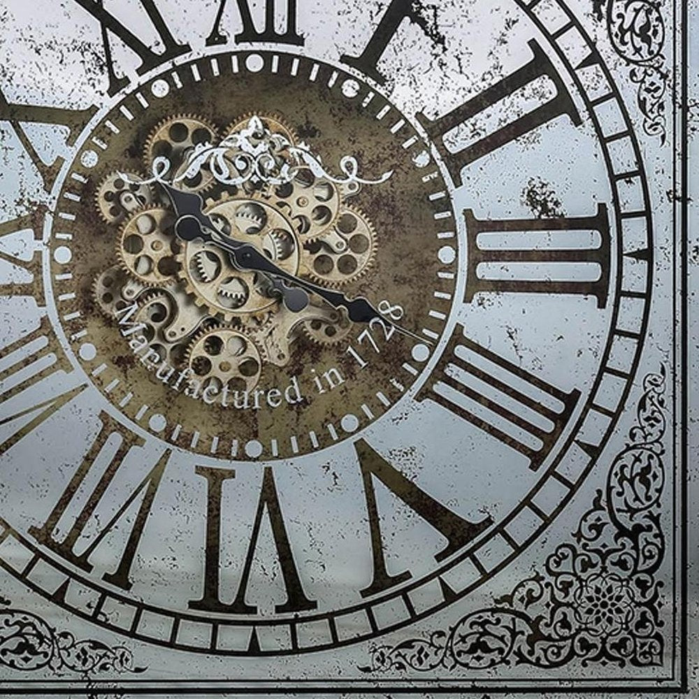 32" Gold And Silver Metal Analog Distressed Square Wall Clock styled in a furnished interior with an off-white wall on a tiled floor.