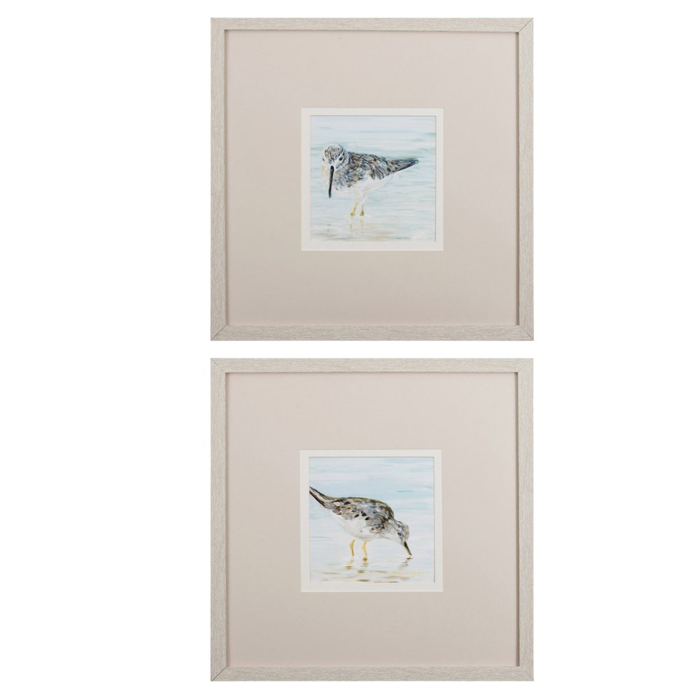 Set of two framed watercolor paintings of sandpipers in shallow water, with light wood frames.