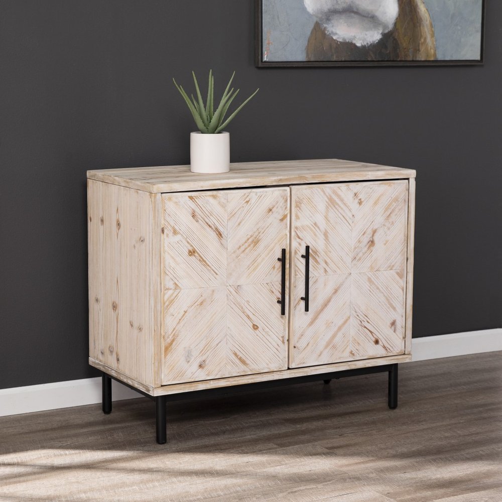 Rustic natural wood accent cabinet with two doors and black legs against a dark gray wall.