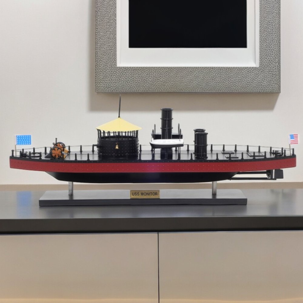 11" Black and Red Solid Wood Hand Painted 1862 USS Monitor Model Boat styled in a furnished interior with an off-white wall on a wood floor.