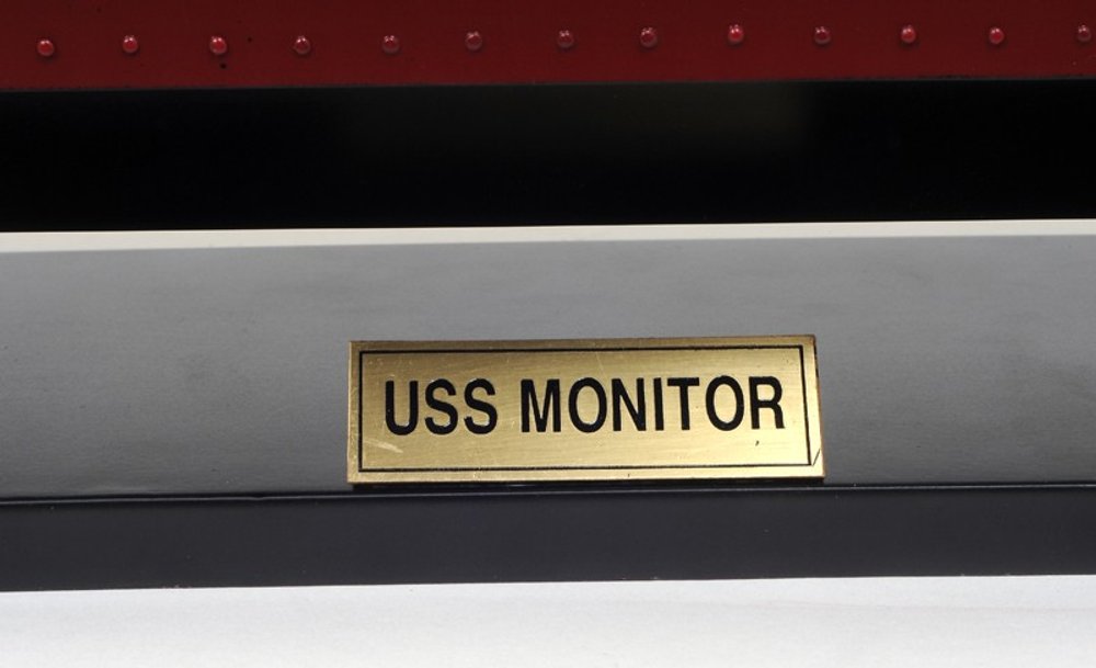 Cropped view of 11" Black and Red Solid Wood Hand Painted 1862 USS Monitor Model Boat focusing on the black wood surface.