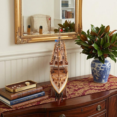 10" Black and Red Solid Wood Hand Painted 1912 RMS Titanic Small Model Boat styled in a furnished interior with an off-white wall on a dark wood floor.